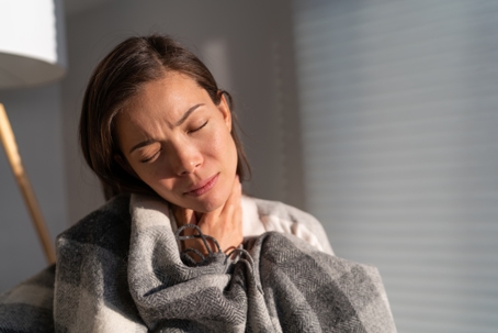 woman with throat pain at home