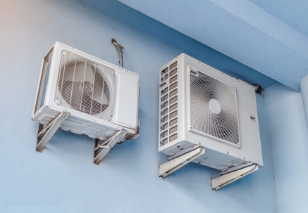 White air conditioners on the blue wall of the house