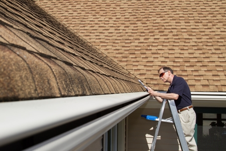 Home inspector examines a home's roof.